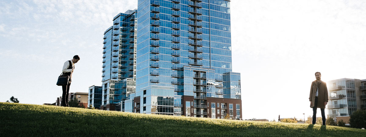 Borlino founder Darrell Ratliff carrying a handmade luxury Italian leather briefcase against a modern city skyline backdrop.
