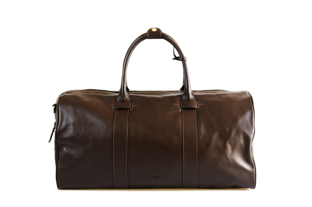 Leather Duffel Bag - This lightweight hand-crafted leather duffel bag is constructed of the finest Italian soft calf leathers. It's perfect for weekend trips that securely fits in the plane overhead. Great for a short trip to the gym or country club as well. The spacious interior also has a secure zippered pocket. Walnut Brown.